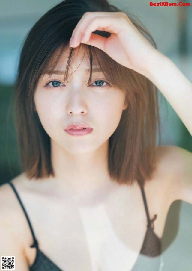 A woman in a black bra top posing for a picture.