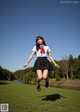 A woman in a school uniform is jumping in the air.