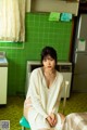 A woman sitting on a chair in a kitchen.