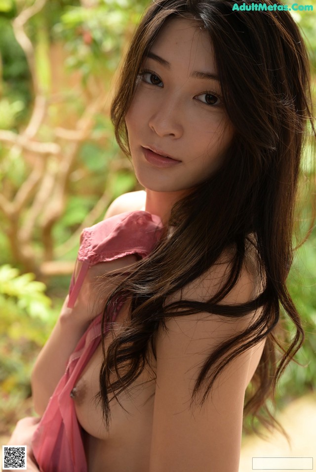 A woman in a pink dress posing for a picture.